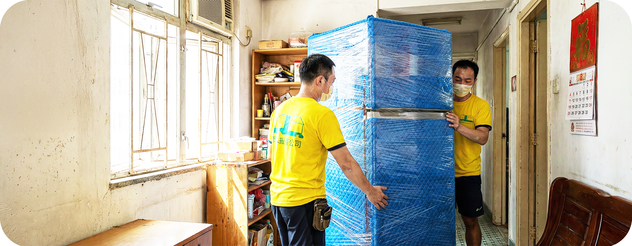 實惠搬屋公司搬運師傅在公屋走廊小心搬運大型雪櫃，展示針對公屋及居屋的高性價比搬屋方案。包含屋邨貨車停泊安排及棄置傢俬服務，是香港公屋住戶首選的經濟搬屋公司推介。