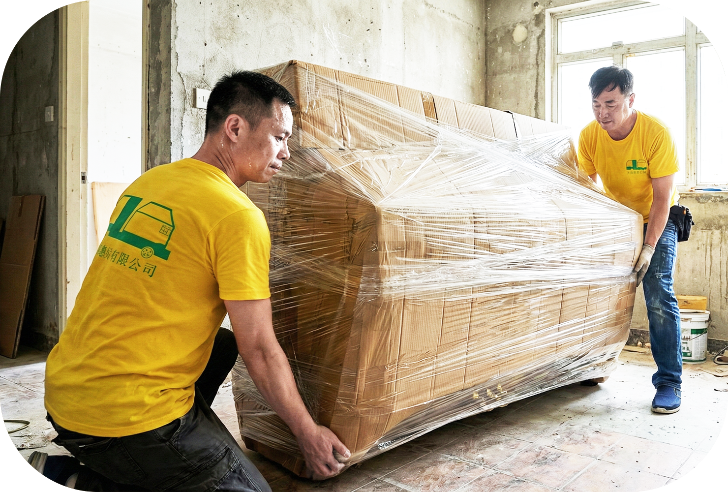 實惠搬屋兩位師傅在裝修工地上，使用紙皮及膠膜為直立式鋼琴進行多層防塵包裹。展示針對家居裝修期間的鋼琴存倉及傢俬暫存服務，避免裝修油漆與沙塵損壞貴重物品。