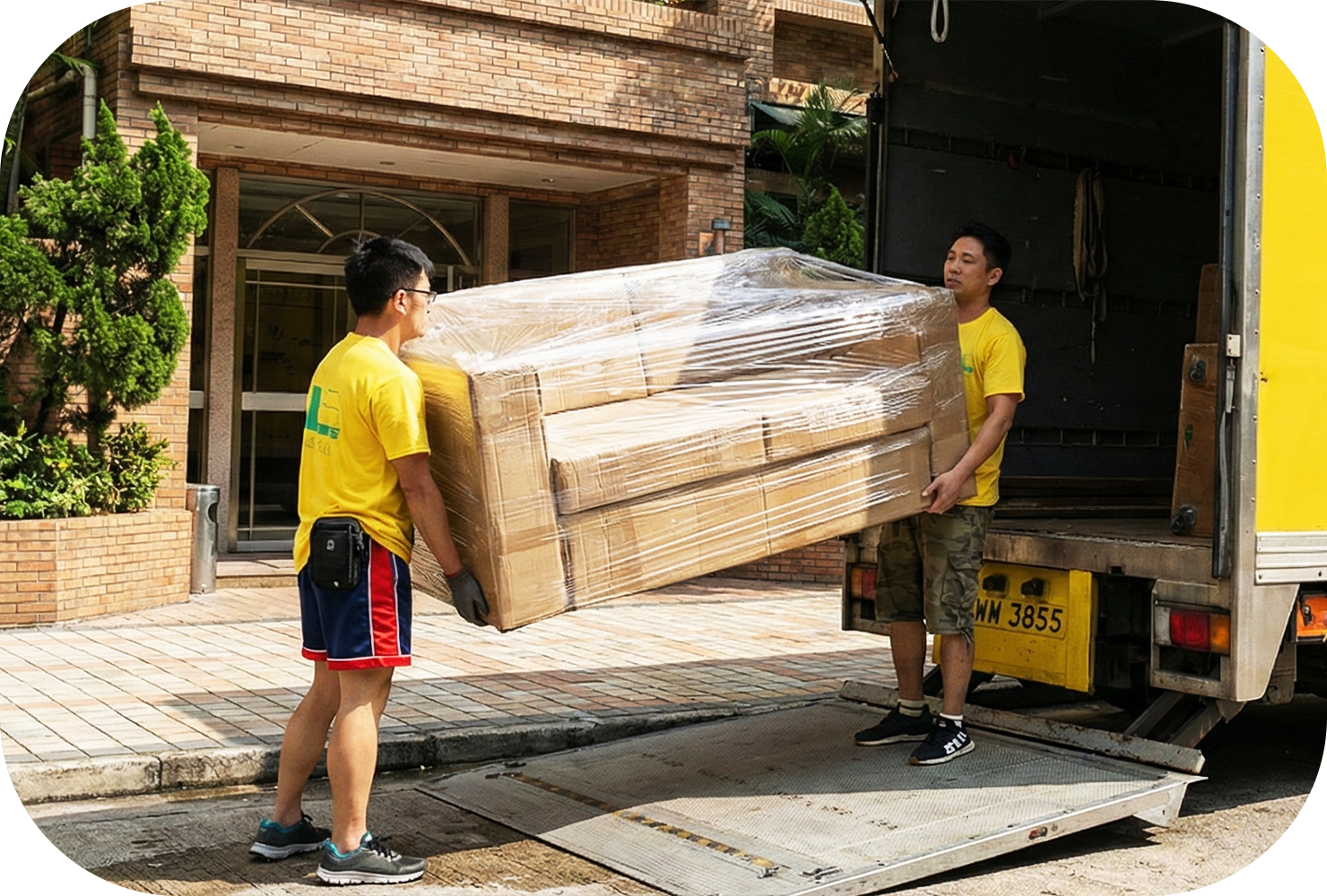 實惠搬屋師傅在住宅大廈外利用貨車尾板搬運已包裝好的梳化，展示解決搬屋交吉期的過渡存倉服務。提供按日或按月計算的靈活租倉方案，完美銜接新舊居所，無需自行租用迷你倉。