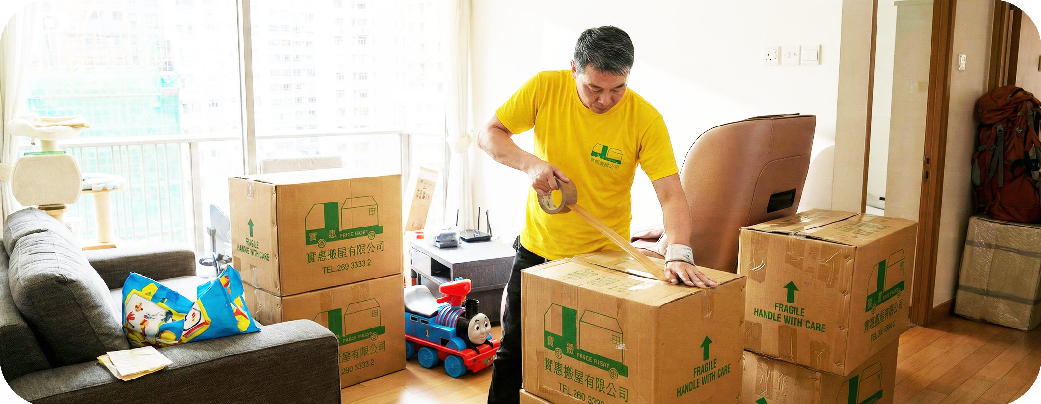 實惠搬屋師傅在政府宿舍內進行封箱打包工作，細心封裝紙箱。展示針對公務員及紀律部隊宿舍的專業搬運服務，熟悉交吉標準及特定搬運時間限制，提供標準化打包入箱服務。