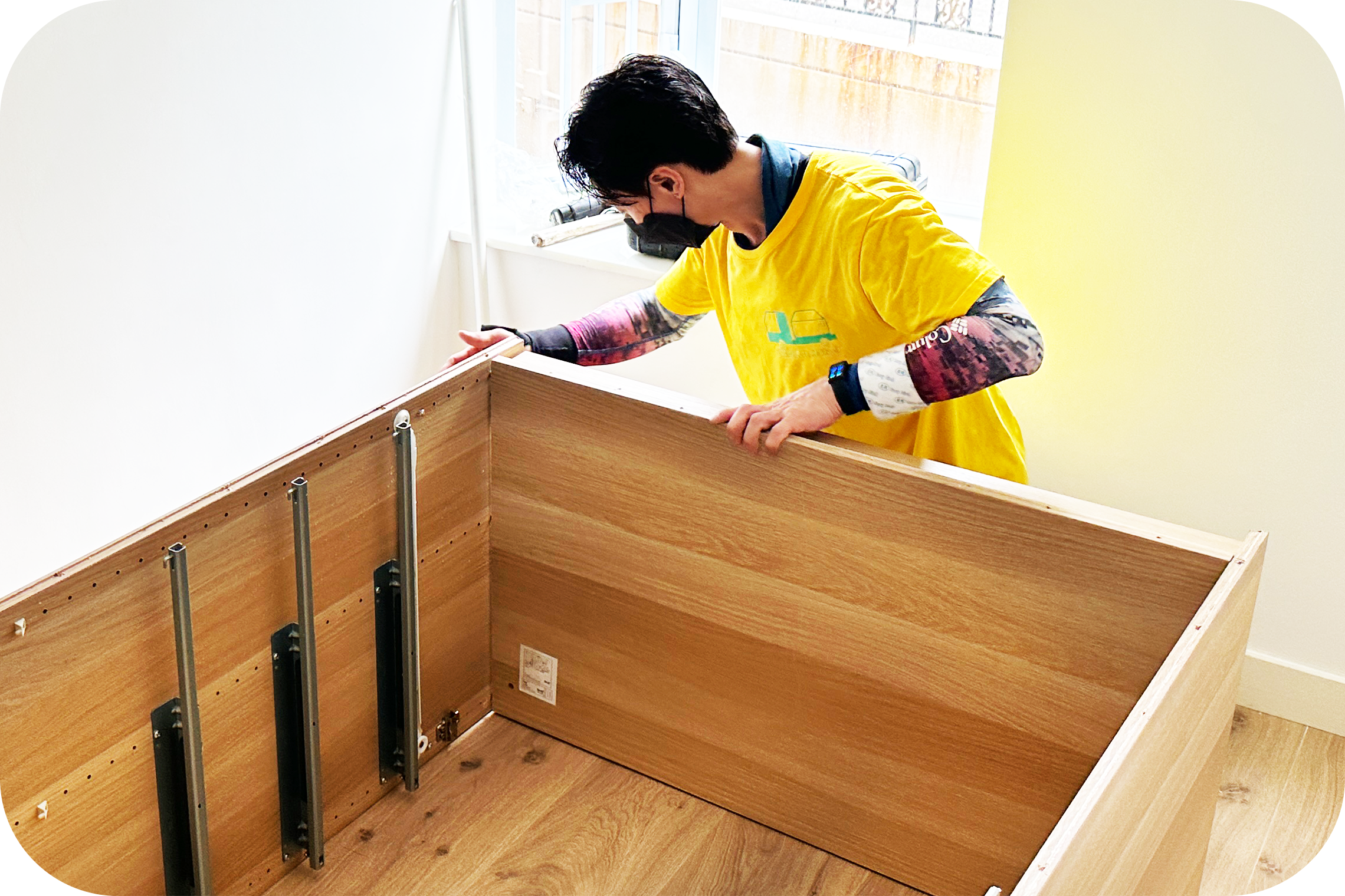 搬運師傅正在使用工具拆卸木製衣櫃以進行合法棄置處理