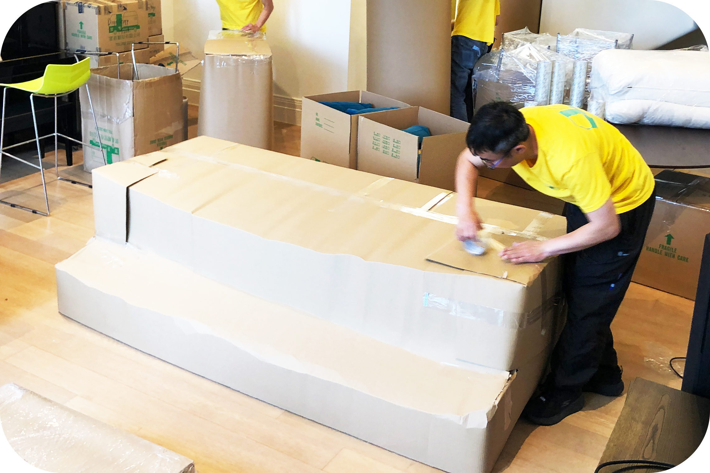 師傅為存倉傢俬進行加厚紙皮包裝以準備入倉暫存