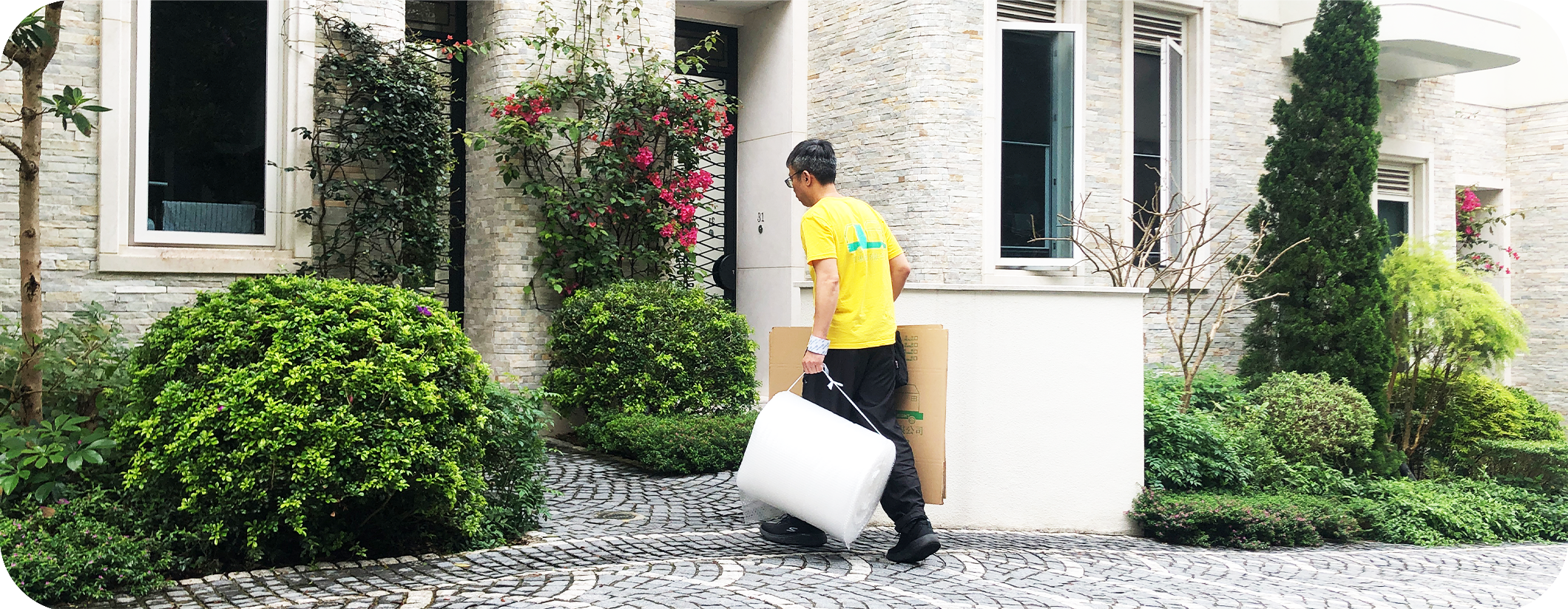 實惠搬屋免運費送箱上門服務：黃衣制服職員將搬屋紙箱及氣泡紙直接送入獨立屋內，展示訂購滿 10 個紙箱即享首次免費送貨的貼心安排。
