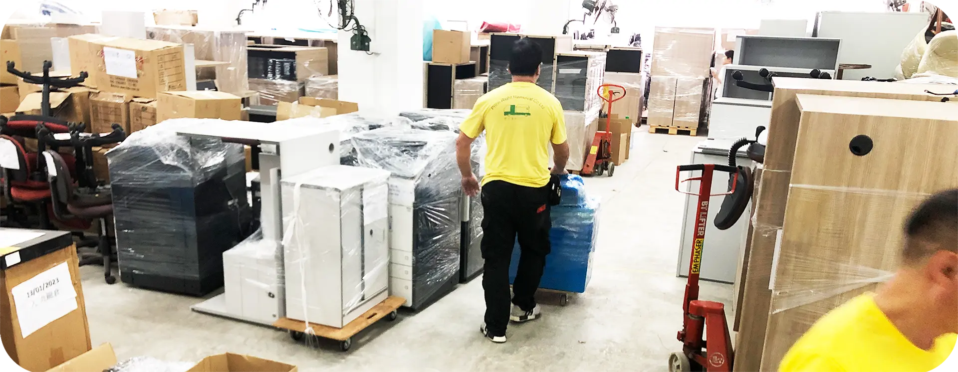 實惠搬屋師傅在工業大廈貨倉內使用油壓唧車(Pallet Jack)搬運重型貨物，展示處理卡板貨物及大規模存貨轉移的專業能力，是工廠及電商倉庫搬運首選。