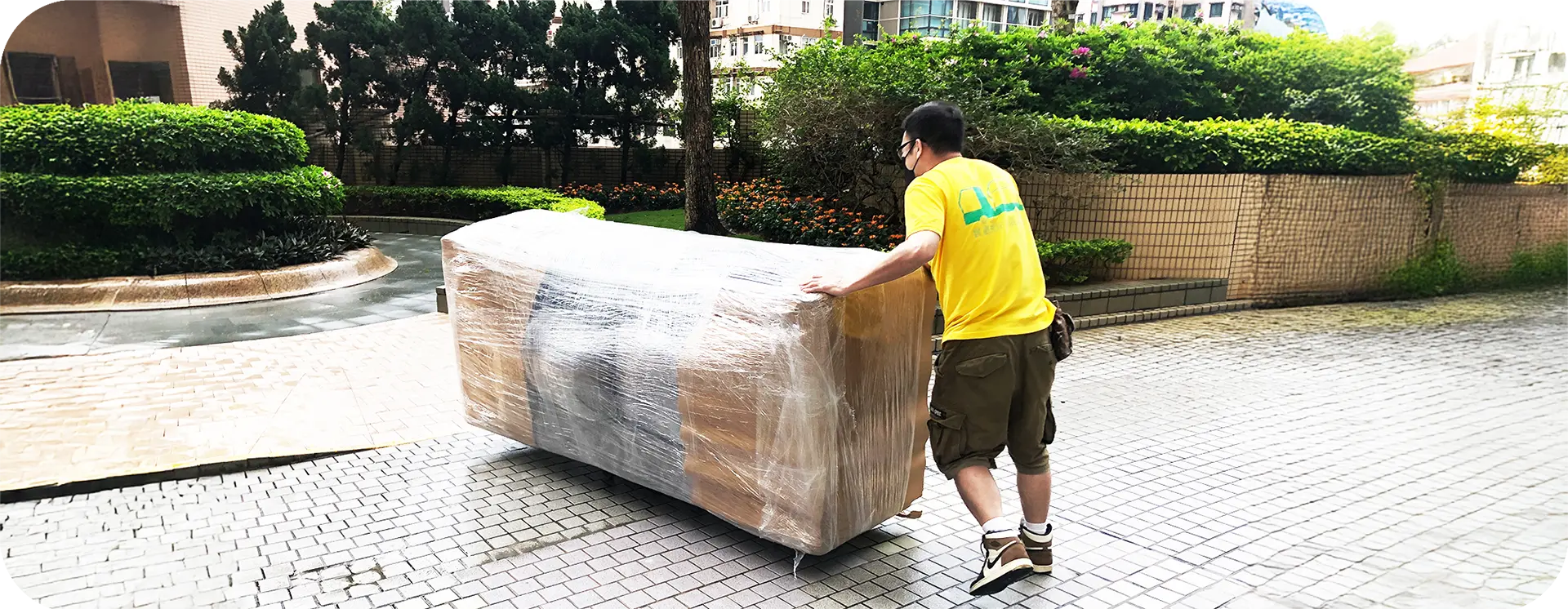 實惠搬屋師傅在大型屋苑平台使用板車進行長距離搬運，展示推遠路費（每推50米平路）的實際操作，收費透明公開，絕無隱藏附加費。