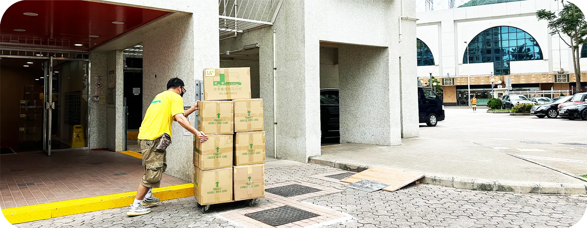 實惠搬屋專業團隊於屋苑平台進行長距離推路搬運服務，細心運送已裝箱的客戶物品。