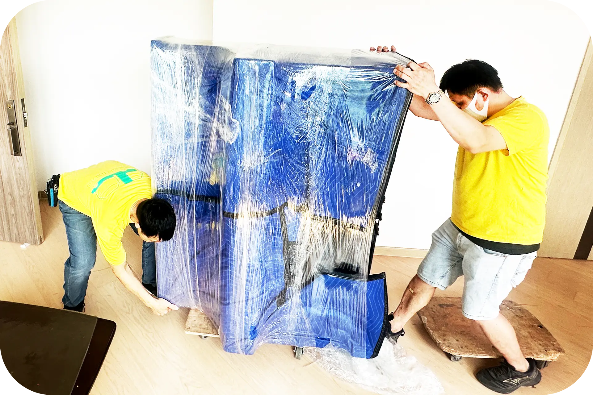 香港搬屋服務 - 實惠搬屋兩名搬屋師傅使用藍色保護墊及膠膜為大型傢俬進行防撞包裝