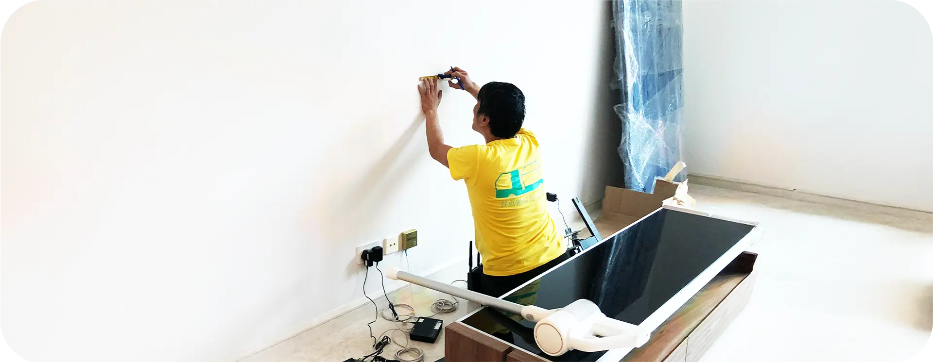 實惠搬屋傢俬拆裝服務：專業師傅進行掛牆電視鑽牆安裝與還原，展示公開透明的拆裝收費標準及水平測量技術。